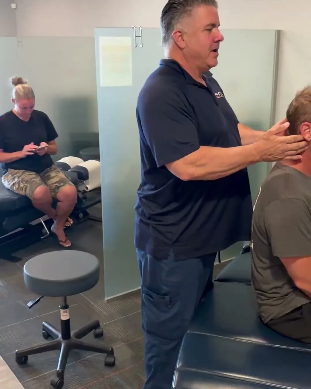 El Dr. Anthony Salmon, DC ajusta el cuello y los hombros de un paciente en Pacific Spine & Rehab en Carlsbad