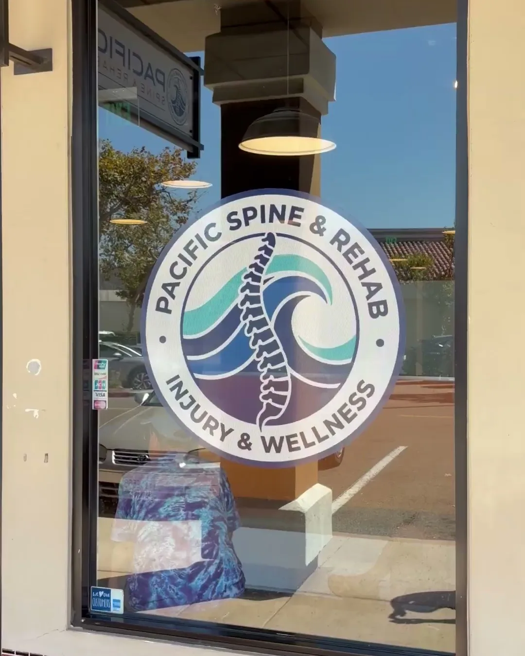 Ventana frontal con el logo de Pacific Spine & Rehab en la oficina de Oceanside
